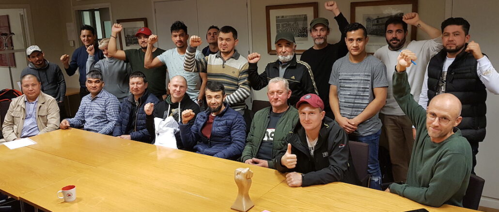 20 byggarbetare samlade i ett konferensrum för medlemsmöte med facket, Stockholms byggsyndikat av SAC Syndikalisterna