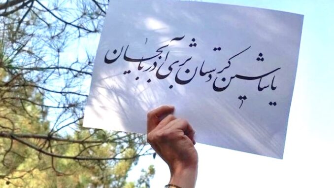 En hand håller upp ett papper med texten: ”Länge leve Kurdistan” på turkiska och ”länge leve Azarbaijan” på kurdiska.