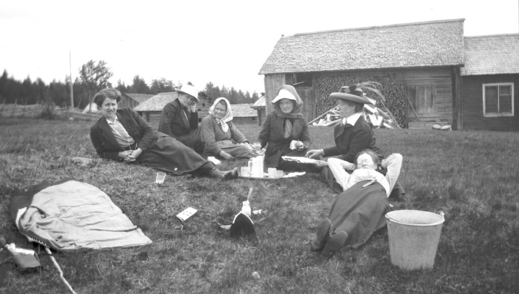 Gammal svartvit bild med kvinnor som har picknick.