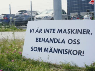 Plakat med texten "Vi är inte maskiner, behandla oss som människor". Utanför Zalandos lager.