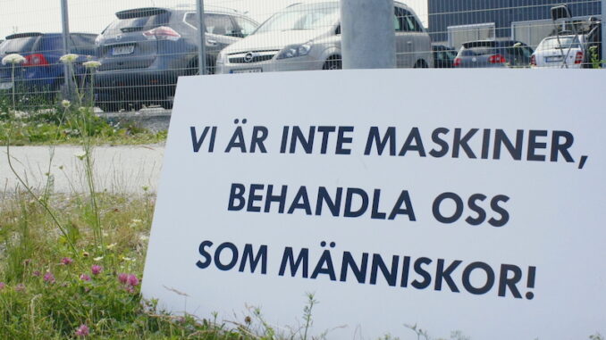 Plakat med texten "Vi är inte maskiner, behandla oss som människor". Utanför Zalandos lager.