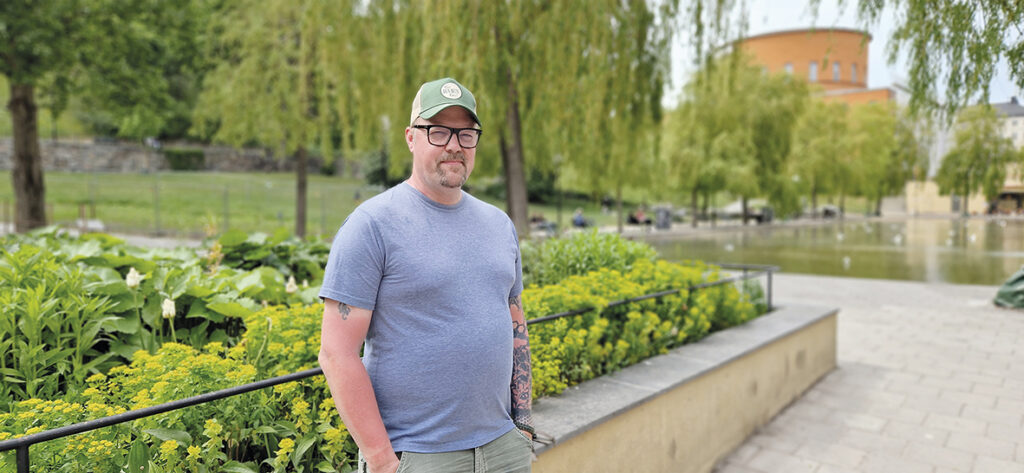 Marcus Vildir står i en park på Sveavägen i Stockholm. Stadsbiblioteket syns i bakgrunden.